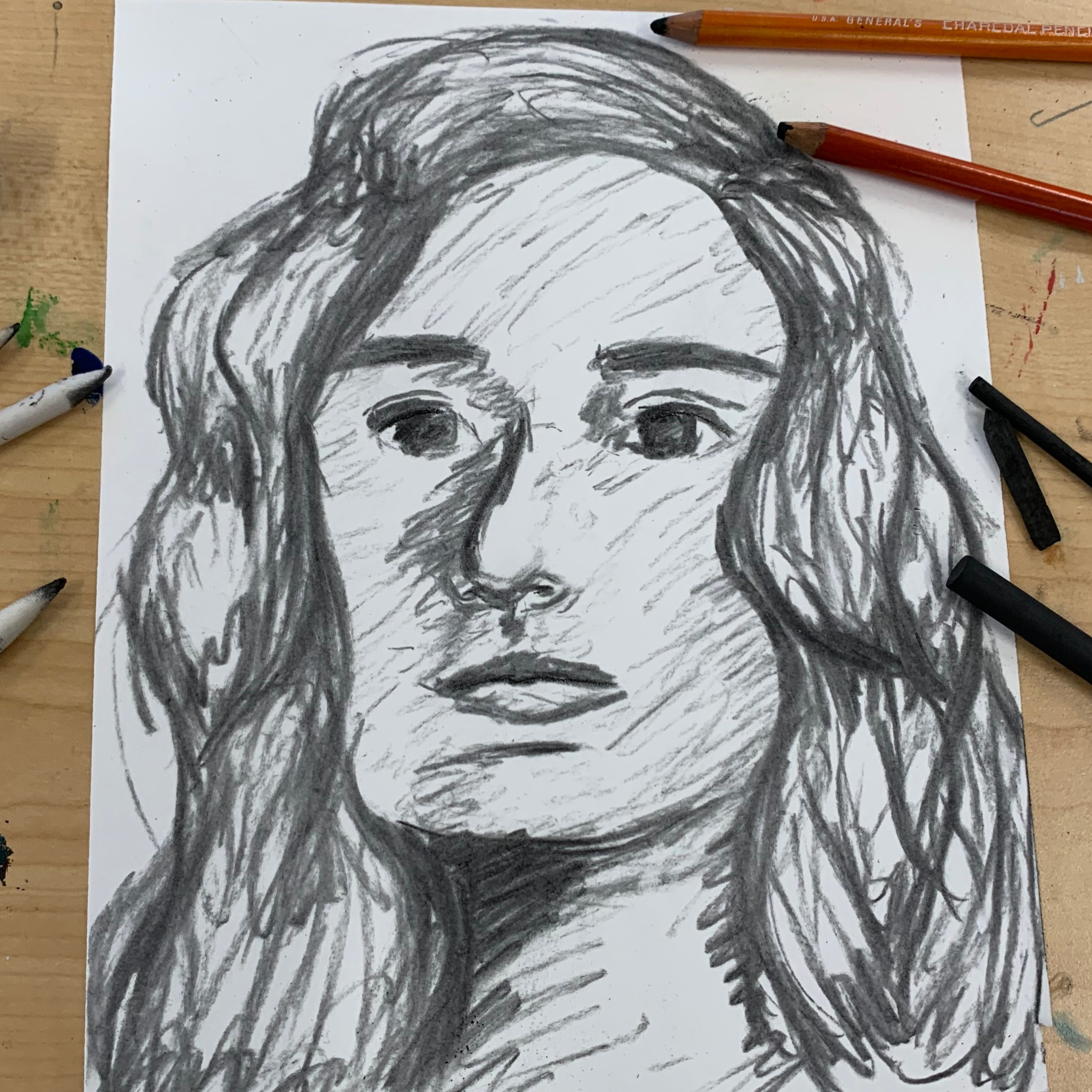 charcoal portrait of a person with wavy hair