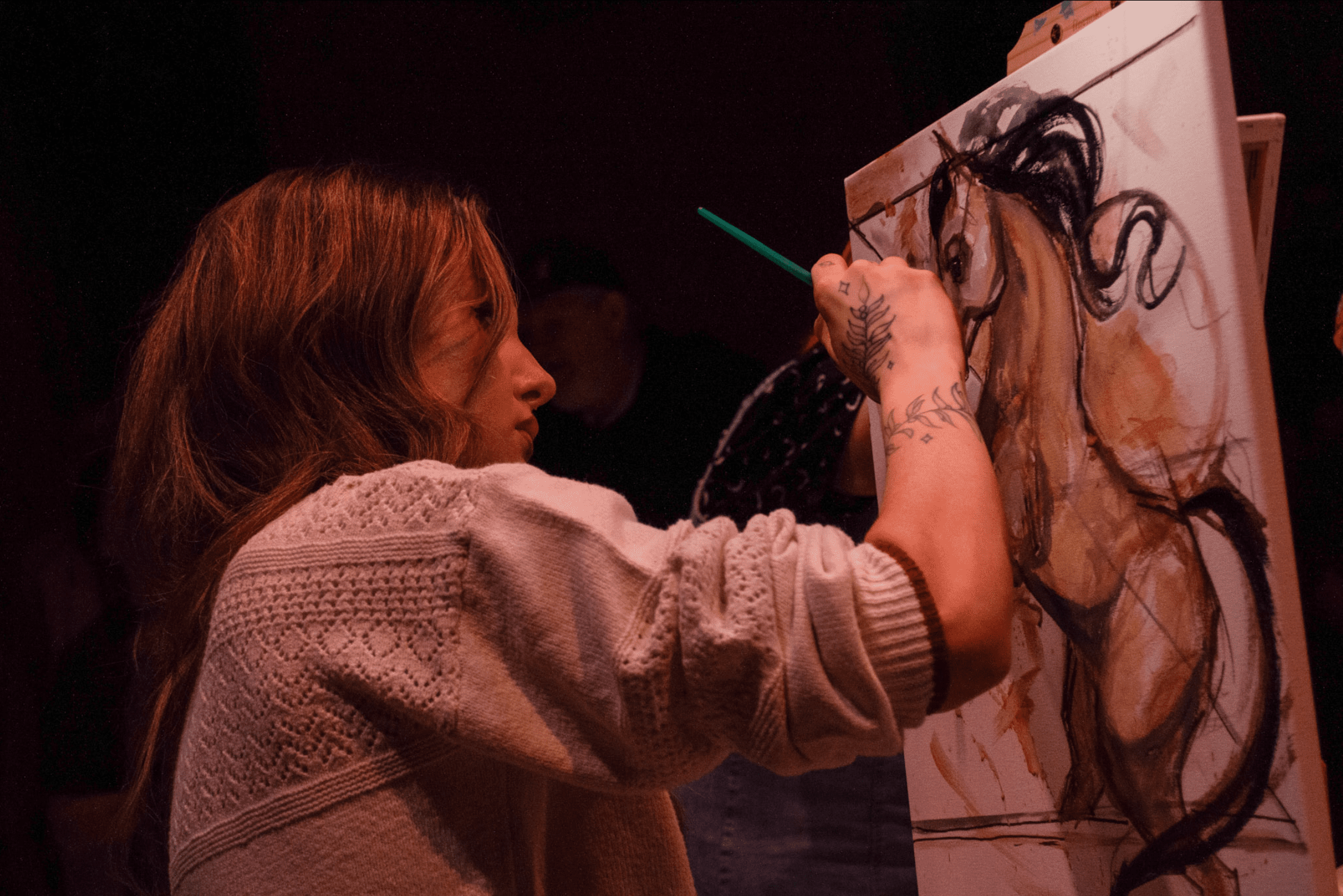Artist actively painting an image of a horse