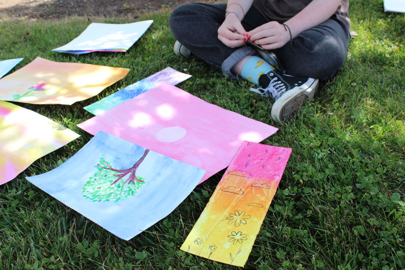 colorful watercolor paintings laid out on the grass